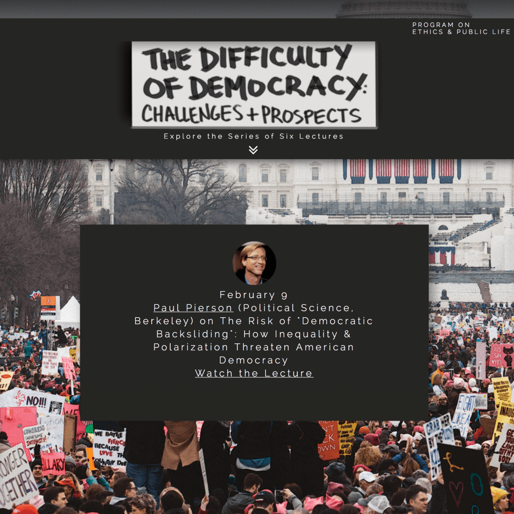 A large crowd gathers at a political rally in front of a government building, holding various protest signs.